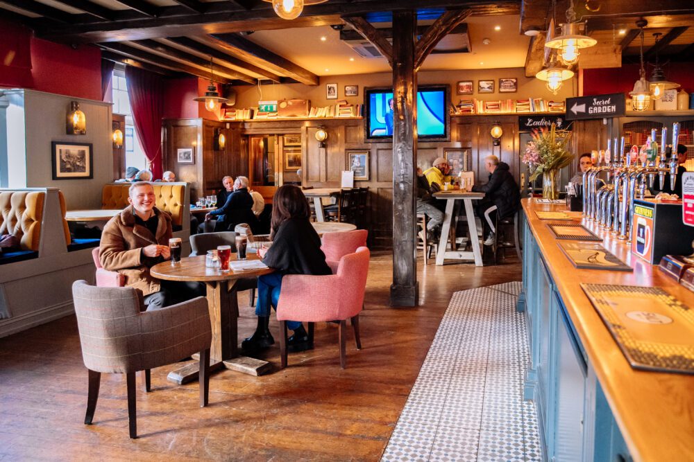 Warm and inviting pub interior with customers enjoying drinks at The Royal Oak
